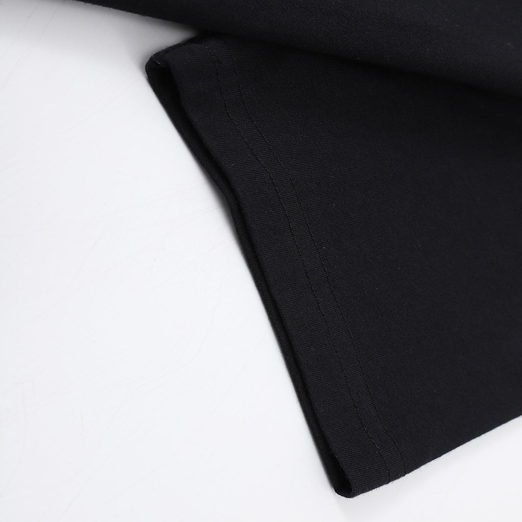 Close-up of the sleeve hem and bottom hem stitching on the black Solstice Graphic T-Shirt