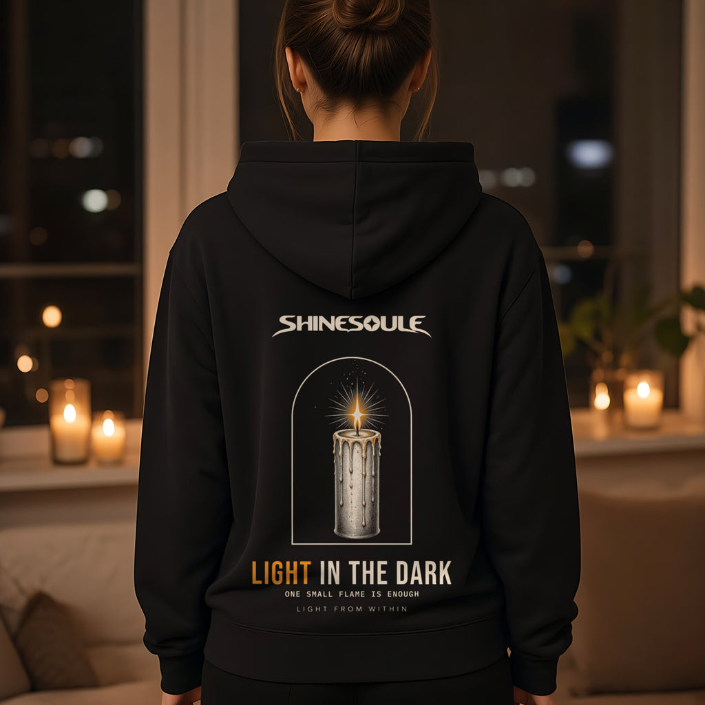Model wearing the Light In The Dark hoodie in black, back view showing the LIGHT IN THE DARK print