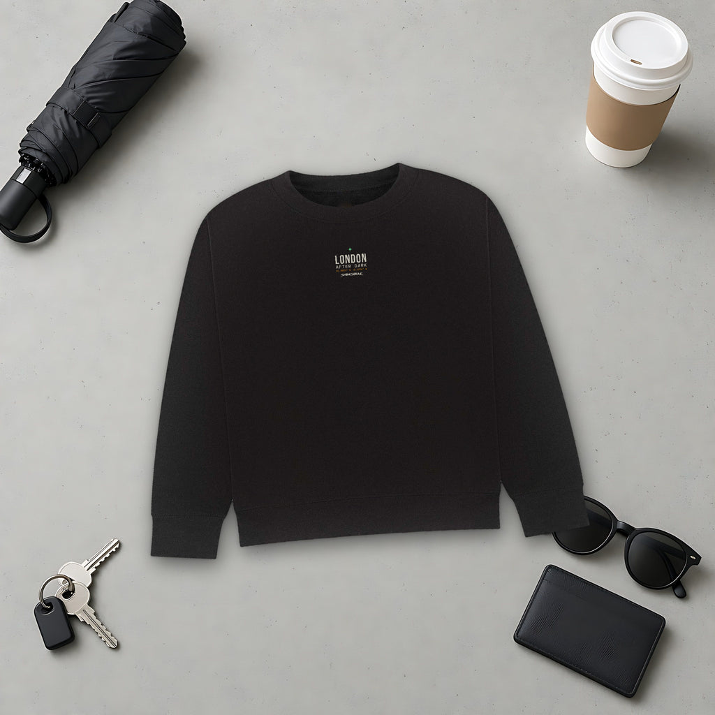 Black London After Dark Graphic Crewneck Sweatshirt flat lay on grey with an umbrella, sunglasses, keys, a phone and a takeaway coffee